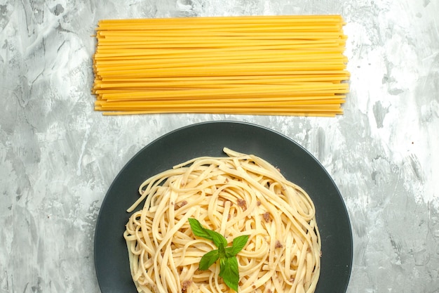 Vista dall'alto gustosa pasta italiana con pasta cruda sullo sfondo bianco
