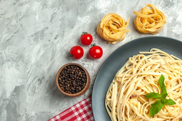 Vista dall'alto gustosa pasta italiana con pomodorini su sfondo bianco