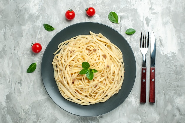 Vista dall'alto gustosa pasta italiana con posate sullo sfondo chiaro