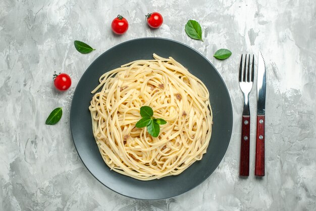 Vista dall'alto gustosa pasta italiana con posate sullo sfondo chiaro