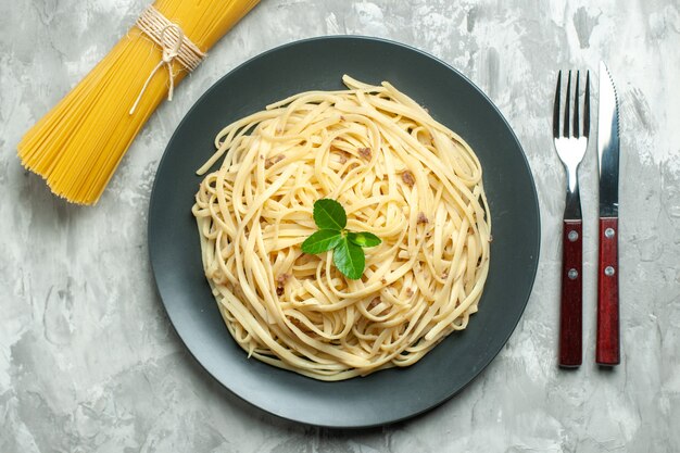 Vista dall'alto gustosa pasta italiana con posate sullo sfondo chiaro