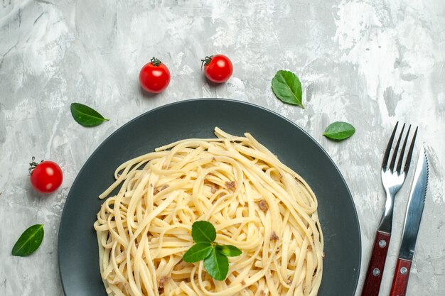 Vista dall'alto gustosa pasta italiana con posate sullo sfondo chiaro