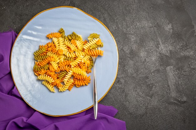 Vista dall'alto gustosa pasta italiana insolita pasta a spirale cotta su grigio