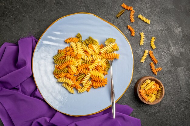 Vista dall'alto gustosa pasta italiana insolita pasta a spirale cotta su grigio