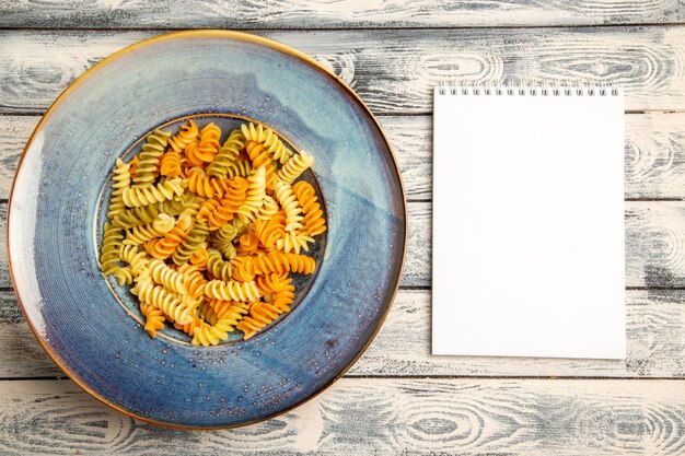 Vista dall'alto gustosa pasta italiana insolita pasta a spirale cotta su grigio