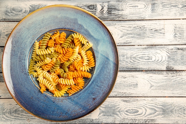 Vista dall'alto gustosa pasta italiana insolita pasta a spirale cotta su legno grigio