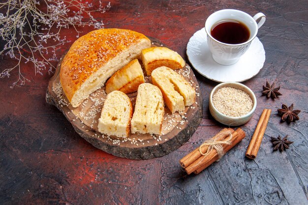 Vista dall'alto gustosa pasticceria dolce con una tazza di tè sulla superficie scura