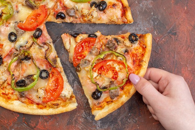 Vista dall'alto gustosa pizza al formaggio affettata e servita su una superficie marrone scuro