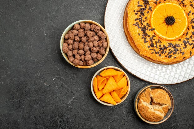 Vista dall'alto gustosa torta dolce con fette d'arancia sulla scrivania grigio scuro torta dolce dessert tè biscotto torta zucchero