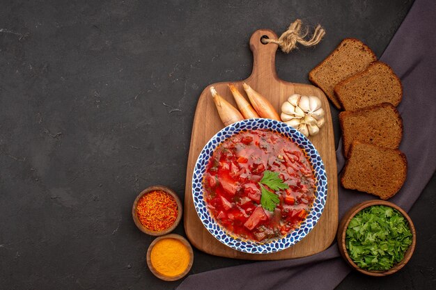 Vista dall'alto gustosa zuppa di barbabietola borsch ucraina con pagnotte di pane scuro sullo spazio buio