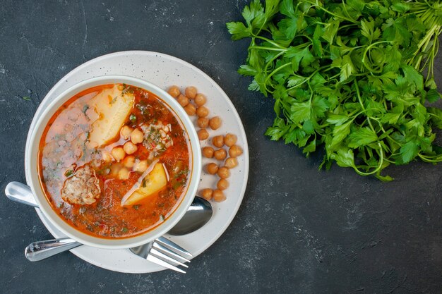 Vista dall'alto gustosa zuppa di carne con fagioli verdi e patate su sfondo scuro