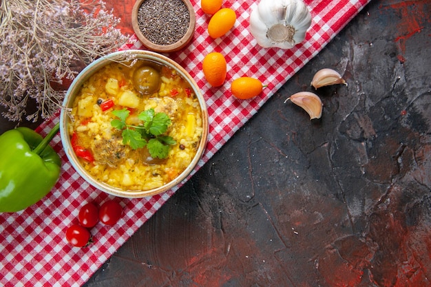 Vista dall'alto gustosa zuppa di carne con patate e riso all'interno di un piattino su superficie scura