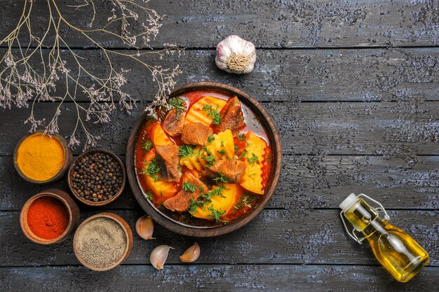 Vista dall'alto gustosa zuppa di carne con patate e verdure sulla scrivania scura