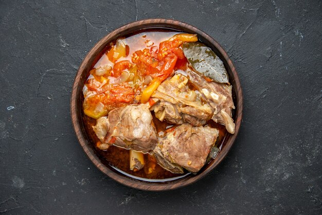 Vista dall'alto gustosa zuppa di carne con verdure su salsa scura piatto da pasto cibo caldo carne patate foto a colori cena cucina