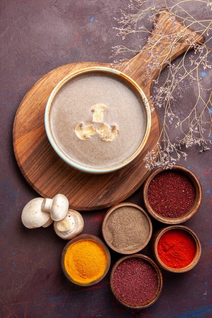 Vista dall'alto gustosa zuppa di funghi con diversi condimenti su sfondo scuro zuppa di condimento a base di funghi cibo