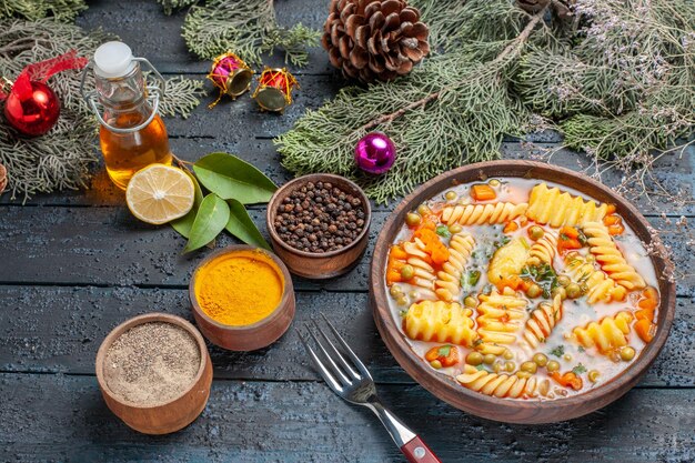 Vista dall'alto gustosa zuppa di pasta da pasta italiana a spirale con verdure su scrivania blu scuro cucina zuppa di pasta piatto per cena colore