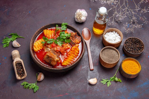 Vista dall'alto gustosa zuppa di ragù di carne con diversi condimenti sul piatto di cena cibo zuppa di salsa di pavimento nero