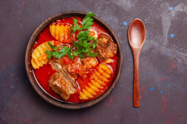 Vista dall'alto gustosa zuppa di ragù di carne con verdure e patate a fette sul nero