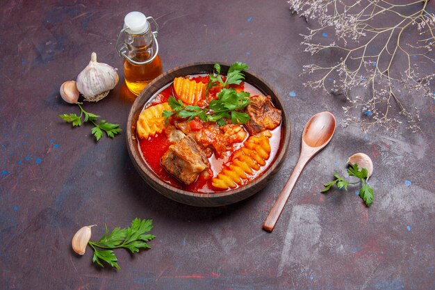 Vista dall'alto gustosa zuppa di ragù di carne con verdure e patate a fette sul nero