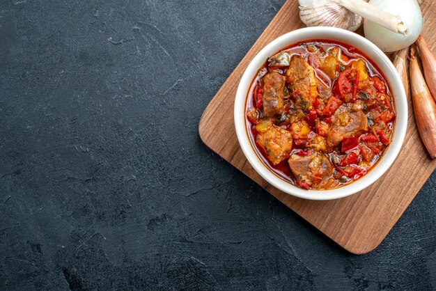 Vista dall'alto gustosa zuppa di verdure con carne su grigio scuro