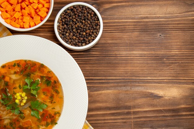 Vista dall'alto gustosa zuppa di verdure con condimenti su una scrivania in legno marrone zuppa di verdure condimenti alimentari