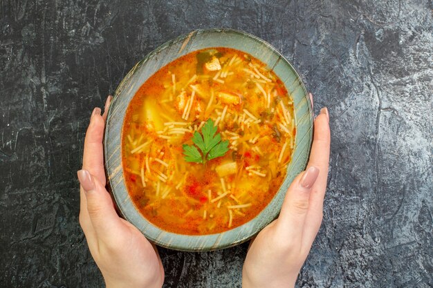 Vista dall'alto gustosa zuppa di vermicelli all'interno del piatto sul tavolo grigio chiaro