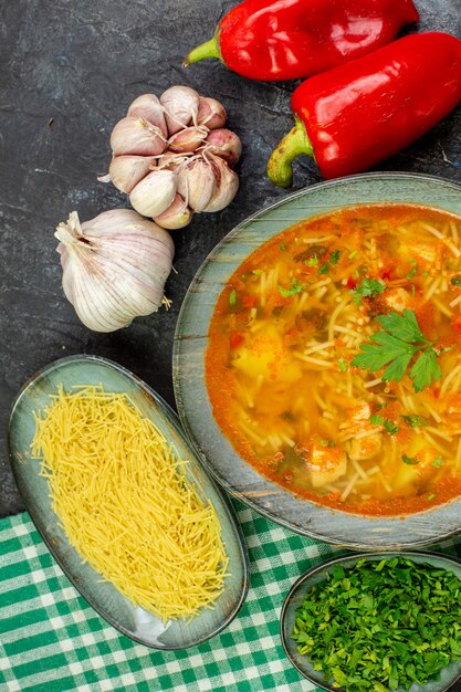 Vista dall'alto gustosa zuppa di vermicelli con aglio e verdure sul tavolo grigio chiaro