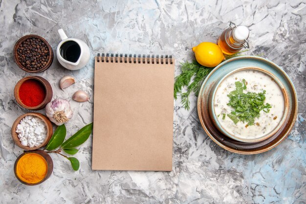 Vista dall'alto gustosa zuppa di yogurt dovga con verdure sul piatto di zuppa di latte tavolo bianco