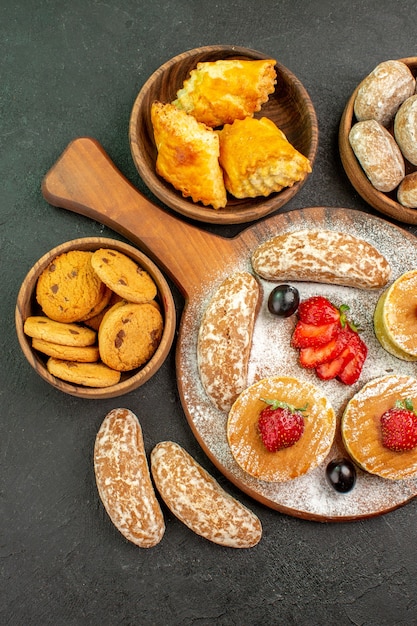 Vista dall'alto gustose frittelle con frutta e torte dolci al buio