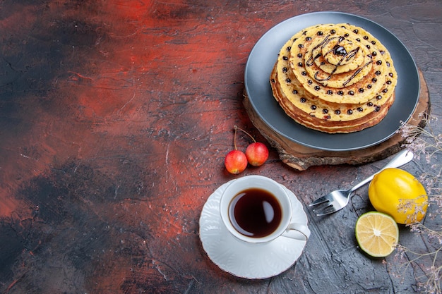 Vista dall'alto gustose frittelle dolci con glassa al cioccolato sulla superficie scura