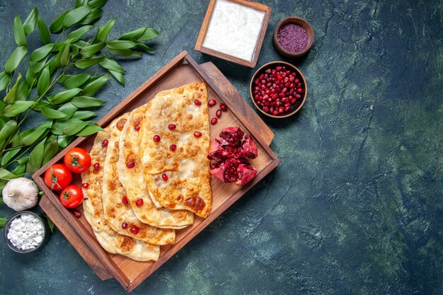 Vista dall'alto gustose frittelle sottili di gutabs con carne all'interno della scrivania su sfondo scuro torta di pasta di focacce color torta al forno