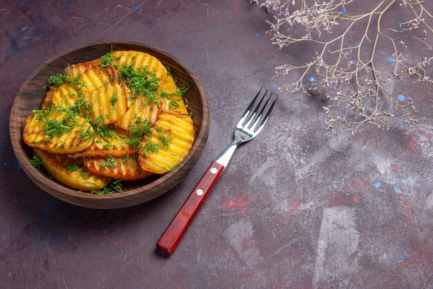 Vista dall'alto gustose patate cotte con verdure all'interno di un piatto marrone su una superficie scura piatto da pasto che cucina patatine cena