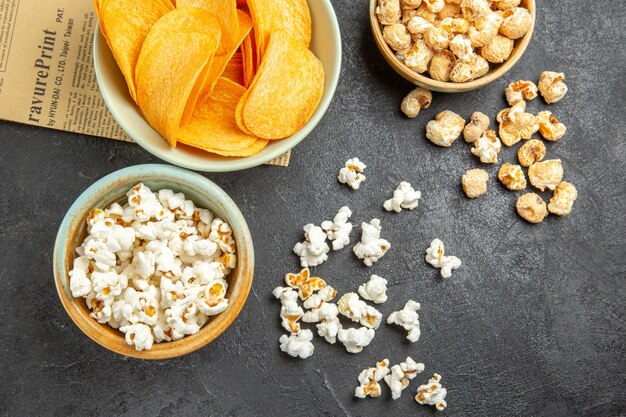 Vista dall'alto gustose patatine al formaggio con diversi snack sullo sfondo scuro