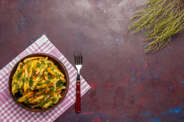 Vista dall'alto gustose patatine fritte con verdure sulla superficie scura