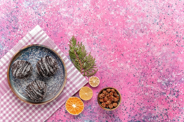 Vista dall'alto gustose torte al cioccolato con fette di limone sul rosa