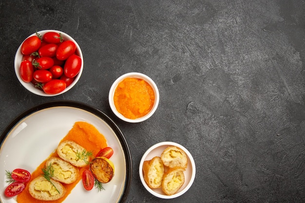 Vista dall'alto gustose torte di patate con zucca e pomodori freschi su forno grigio per cena da tavolo cuocere una fetta di piatto colorato