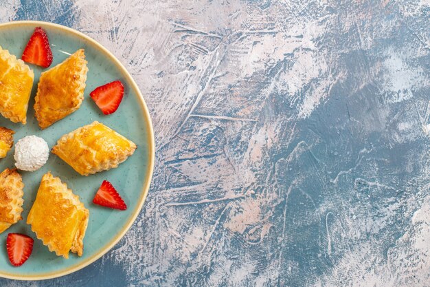 Vista dall'alto gustose torte dolci con fragole su sfondo blu