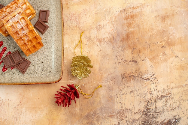 Vista dall'alto gustose torte waffle con barrette di cioccolato sullo sfondo marrone