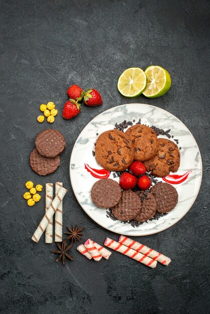 Vista dall'alto gustosi biscotti al cioccolato per il tè su sfondo scuro tè dolce zucchero biscotto