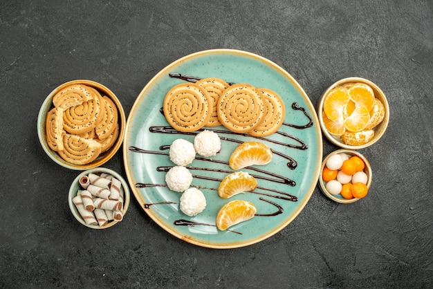 Vista dall'alto gustosi biscotti di zucchero con caramelle su sfondo grigio