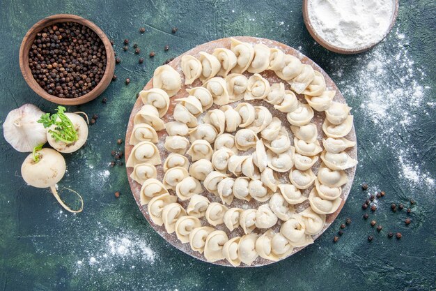 Vista dall'alto gustosi gnocchi con farina sullo sfondo scuro pasta colore cibo pasto cibo piatto carne calorie