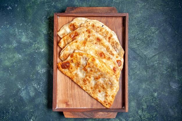 Vista dall'alto gustosi gutabs sottili hotcakes con carne all'interno della scrivania su sfondo scuro colore hotcake pasta pasto torta al forno torta di pasticceria