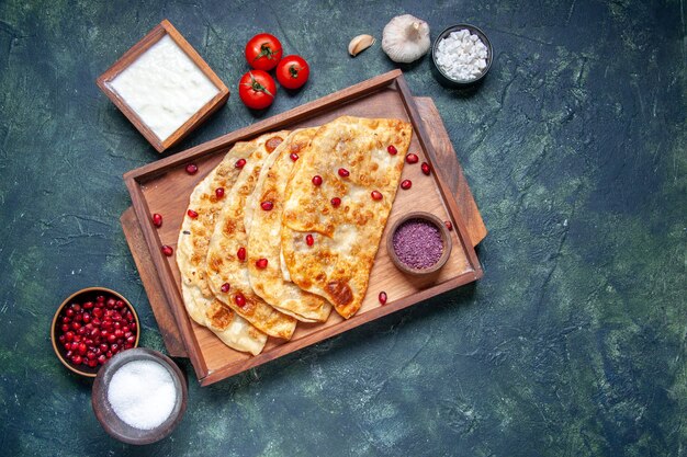 Vista dall'alto gustosi gutabs sottili hotcakes con carne all'interno della scrivania su sfondo scuro colore pasta forno torta pasticceria torta pasto hotcake