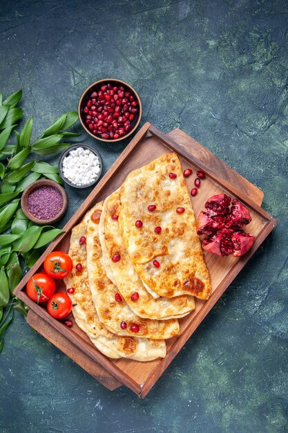 Vista dall'alto gustosi gutabs sottili hotcakes con carne all'interno della scrivania su sfondo scuro hotcake pasta colori torta pasticceria forno torta pasto