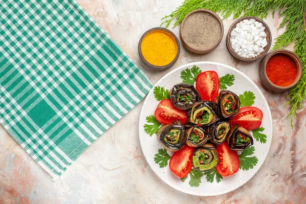 Vista dall'alto gustosi involtini di melanzane con condimenti pomodori e verdure