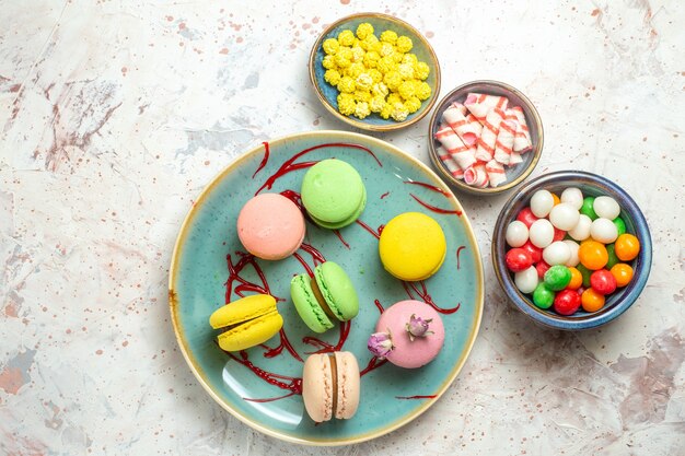 Vista dall'alto gustosi macarons francesi con caramelle su biscotto bianco torta biscotto