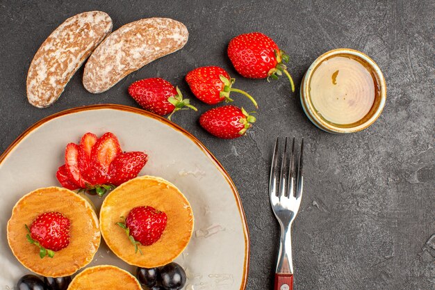 Vista dall'alto gustosi pancake con frutta al buio