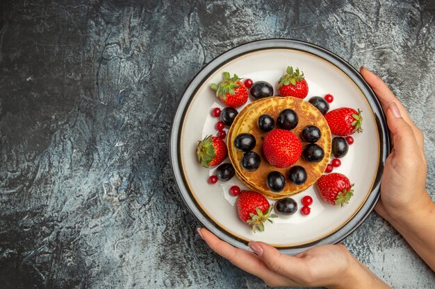 Vista dall'alto gustosi pancake con frutta fresca alla luce