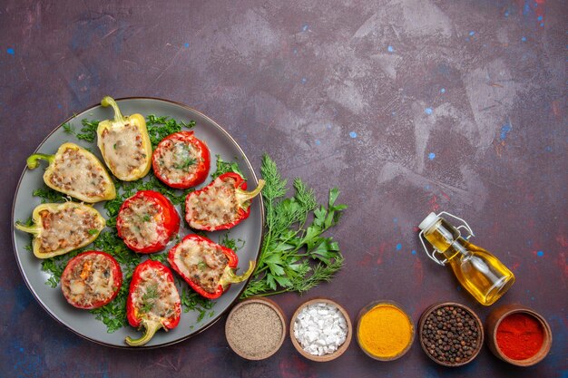 Vista dall'alto gustosi peperoni deliziosi pasto cotto con carne e verdure su piatto di superficie scura cena cibo