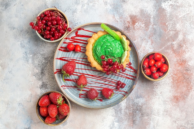 Vista dall'alto gustosissima torta cremosa con frutta fresca su dolce torta da dessert biscotto pavimento chiaro